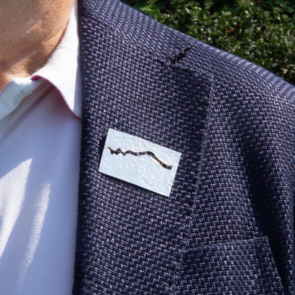 Refraction-wave brooch worn on man lapel